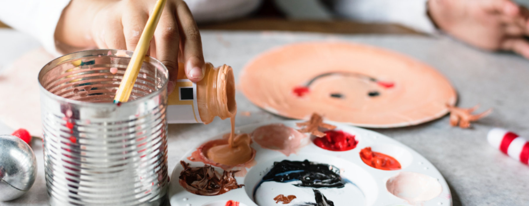 A child pouring paint into a tray